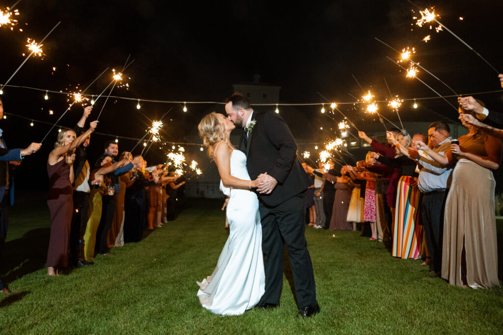 couple kissing at sparkler exit